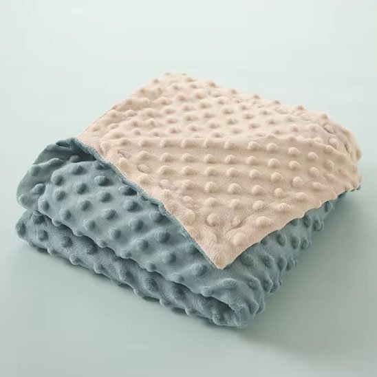 Couverture bébé bleu beige pliée