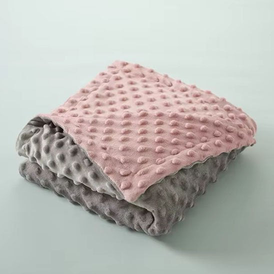 Couverture bébé rose gris pliée